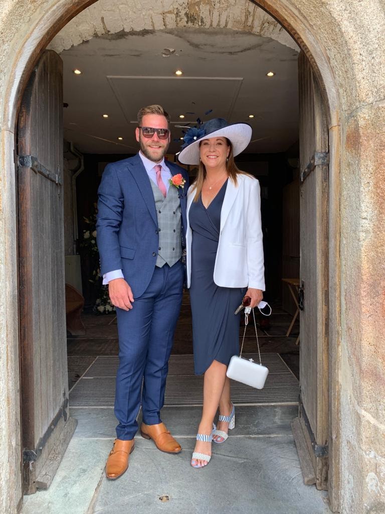 Mother of the groom in hat with son on wedding day